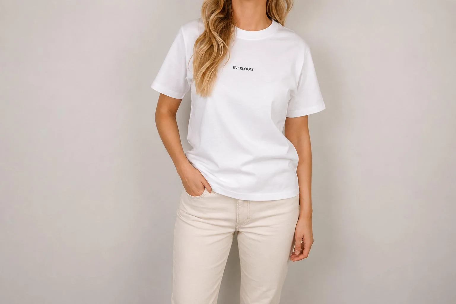 T-shirt branca Everloom em algodão, com logótipo ao centro, usada com calças cor de creme